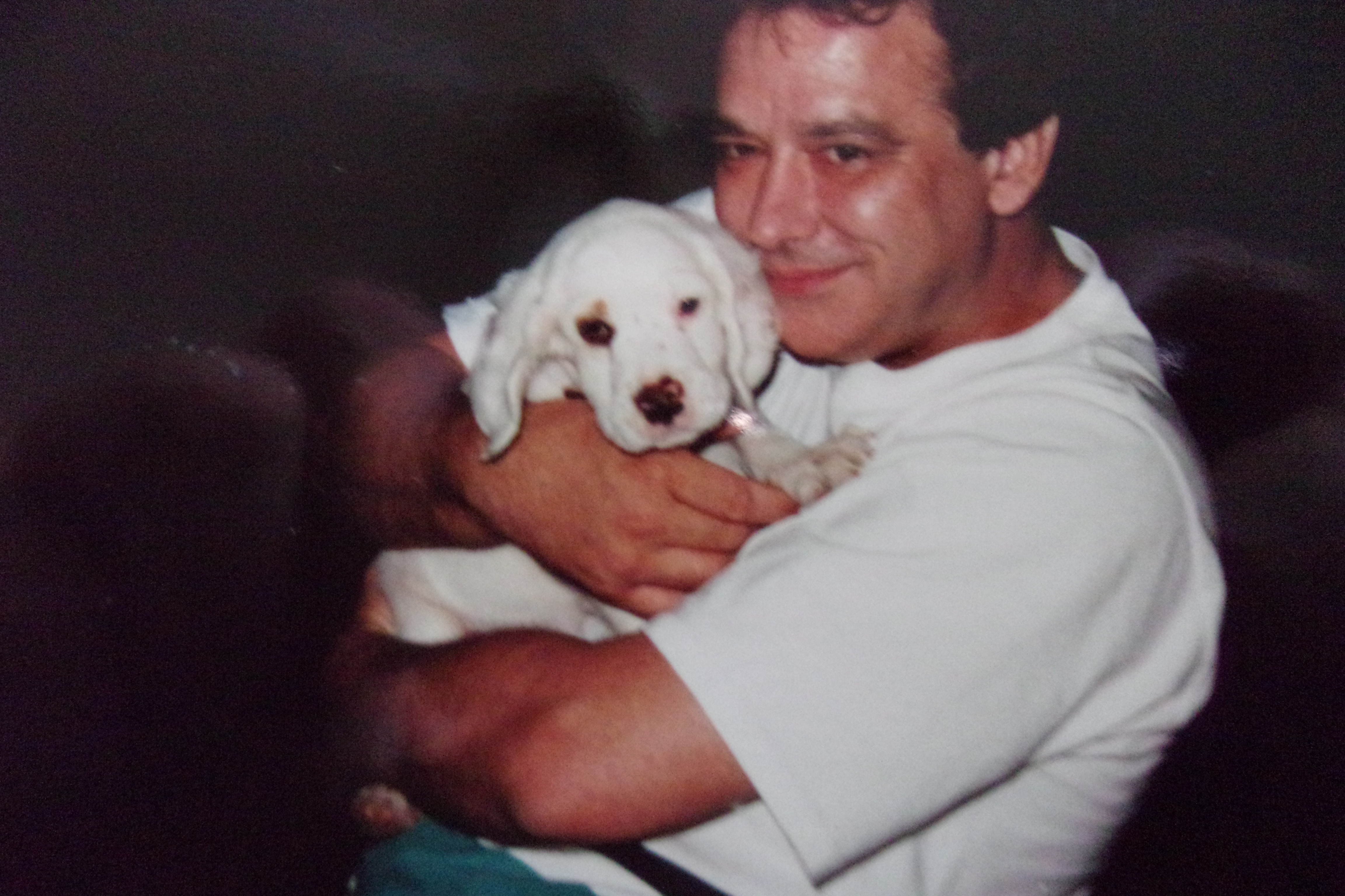 John Michael holding a white puppy